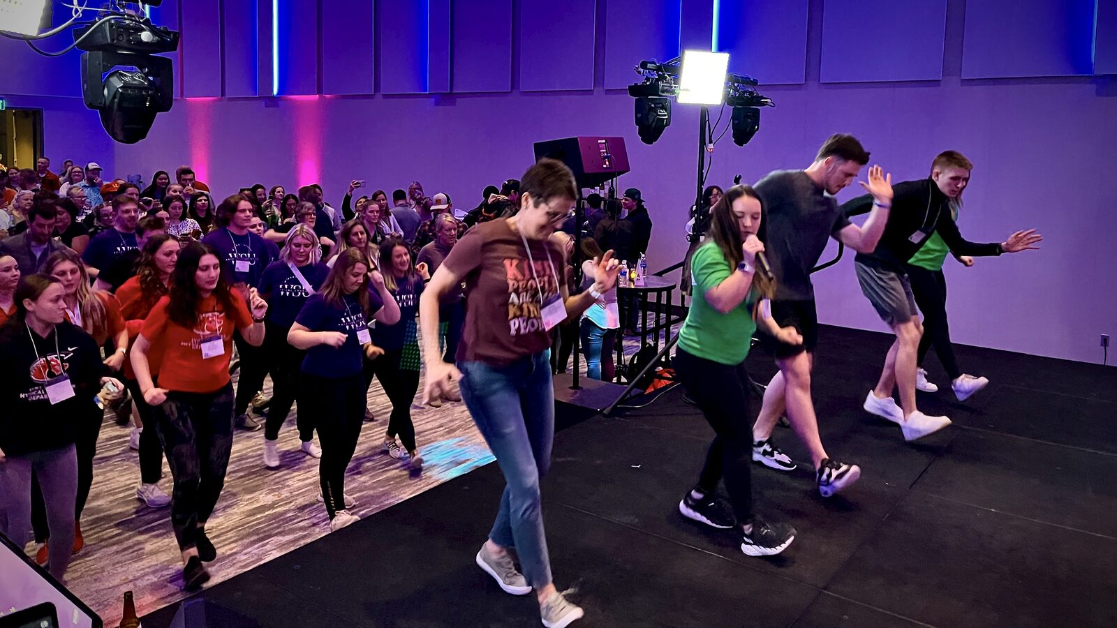 Coworkers singing hosted karaoke at a DJ Illusion corporate team-building event
