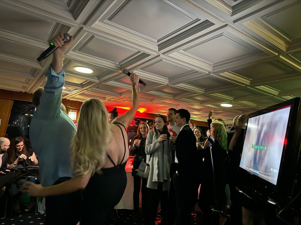 Guests singing and dancing at a Seattle holiday party with DJ Illusion
