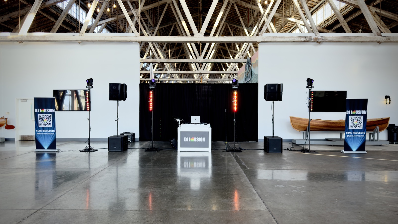 DJ Illusion Premier package setup with four lighting totems and JBL sound system in large event venue