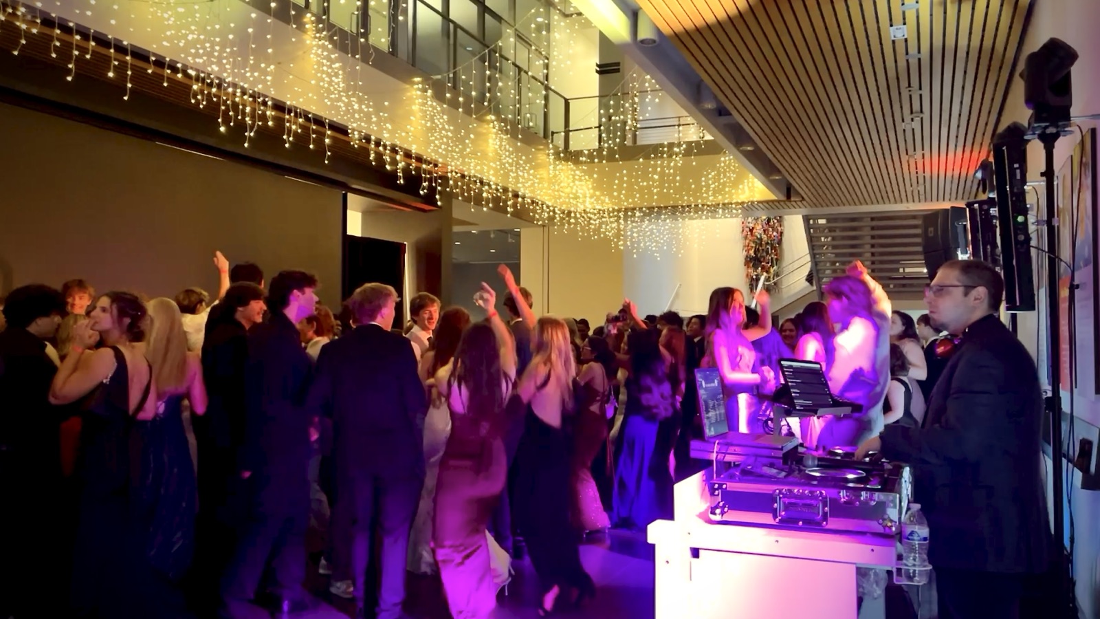 Students dancing at a homecoming dance with DJ Illusion club lighting and a packed dance floor